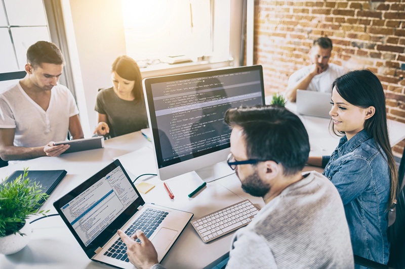 An agency team working around code and monitors