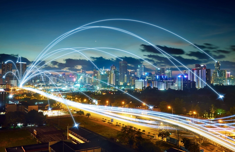 Glowing network connections over a night-time city skyline